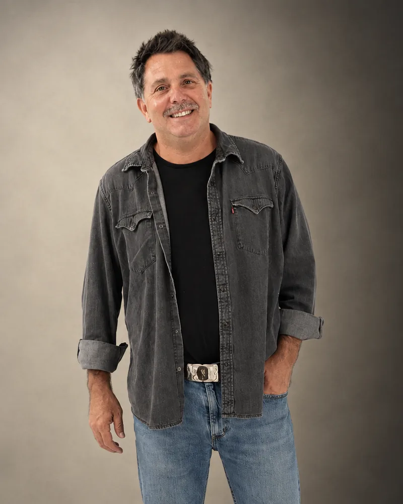Joshua Semolik smiling in a warmly lit, cinematic studio portrait