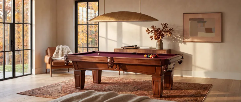 AI-assisted fall room scene from the live Billiard Factory storefront, with pool table, pendant lighting, artwork and rug