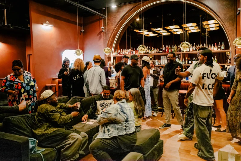 Guests gathered around green seating and the arched bar in the Blue Note Los Angeles lounge