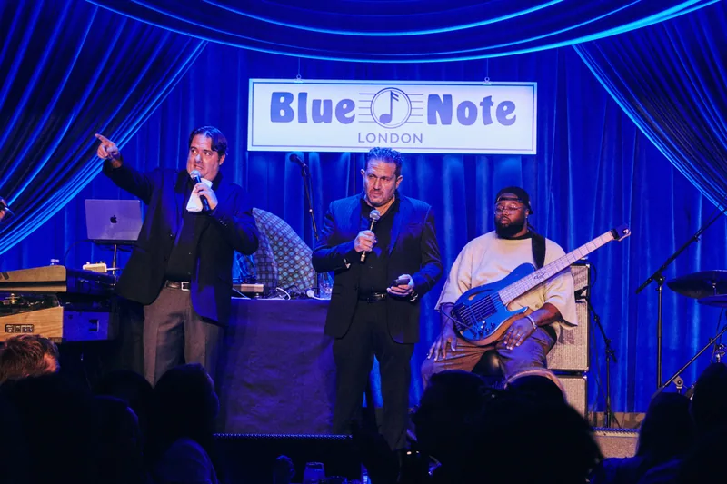 Opening remarks on stage beneath the Blue Note London sign