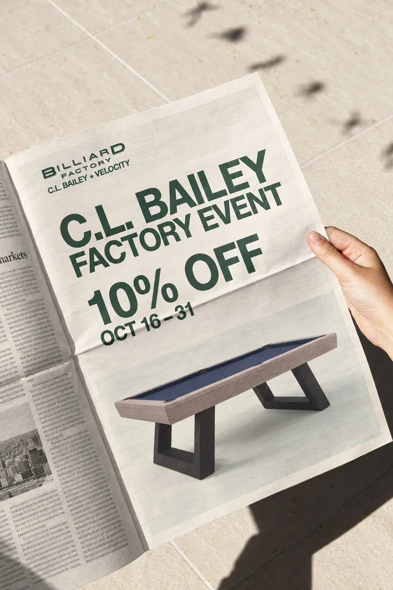 A reader holding a newspaper with C.L. Bailey Factory Event advertising in a campaign mockup
