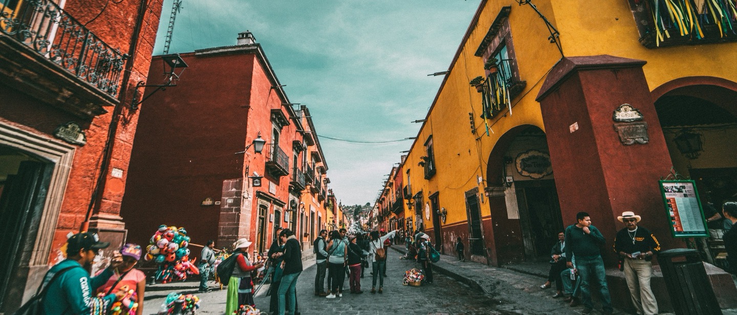 Colorful colonial street in San Miguel de Allende with warm red and yellow buildings